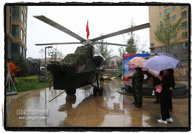 小區(qū)突然出現(xiàn)“飛機(jī)坦克”，其中殲15艦載戰(zhàn)斗機(jī)一架、99式主戰(zhàn)坦克一輛、武直-10武裝直升機(jī)一架，吸引了眾多市民雨中圍觀、合影。